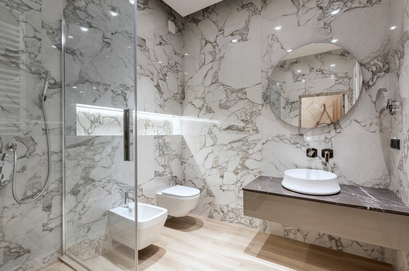 Marble-effect wall tiles in a shower room with a basin